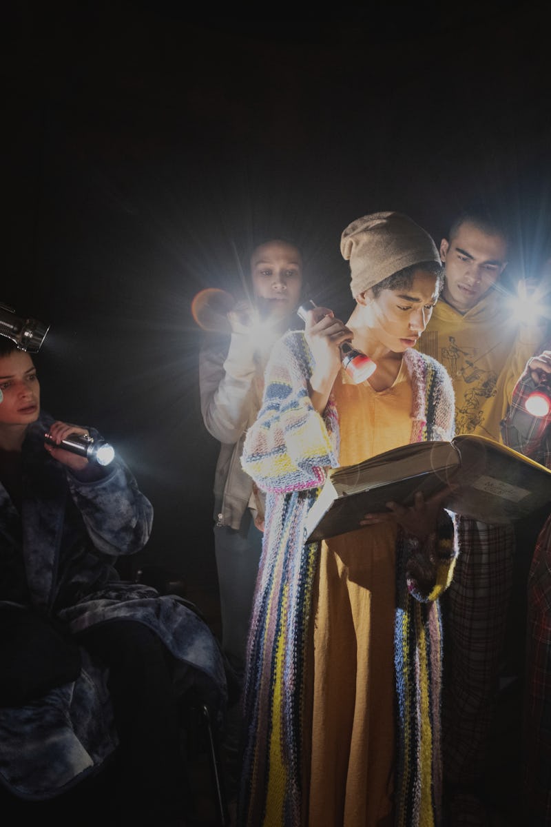 A scene from the Midnight Club with the characters holding flashlights while one of them is looking ...