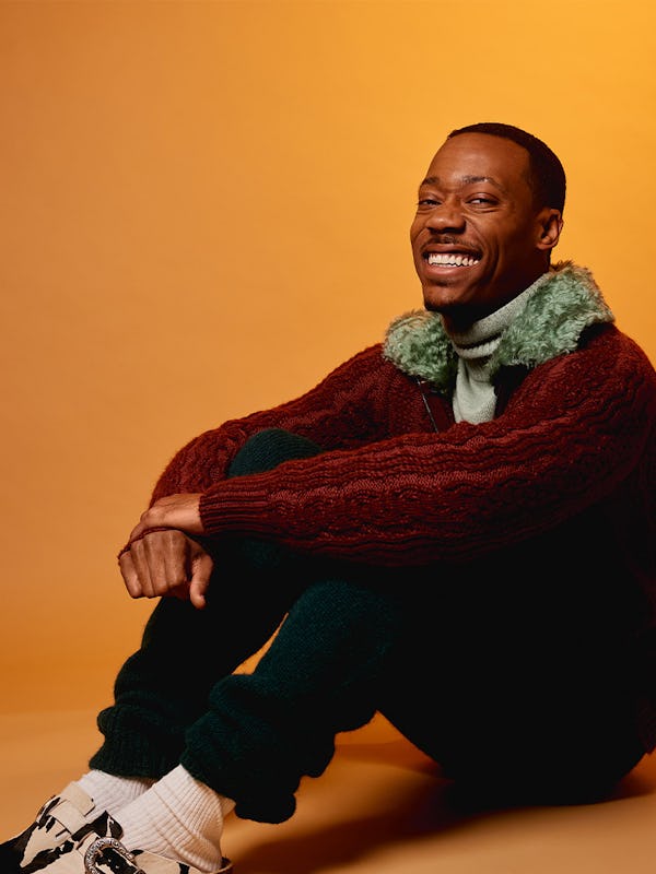 A red jacket and white sweater trending outfit worn by Tyler James Williams