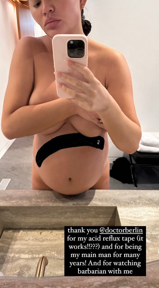 Chrissy Teigen poses to show off her acid reflux tape.