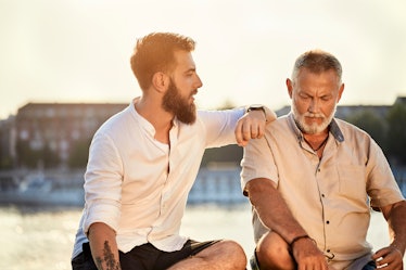 Man talking to his elderly father outside as the sun sets