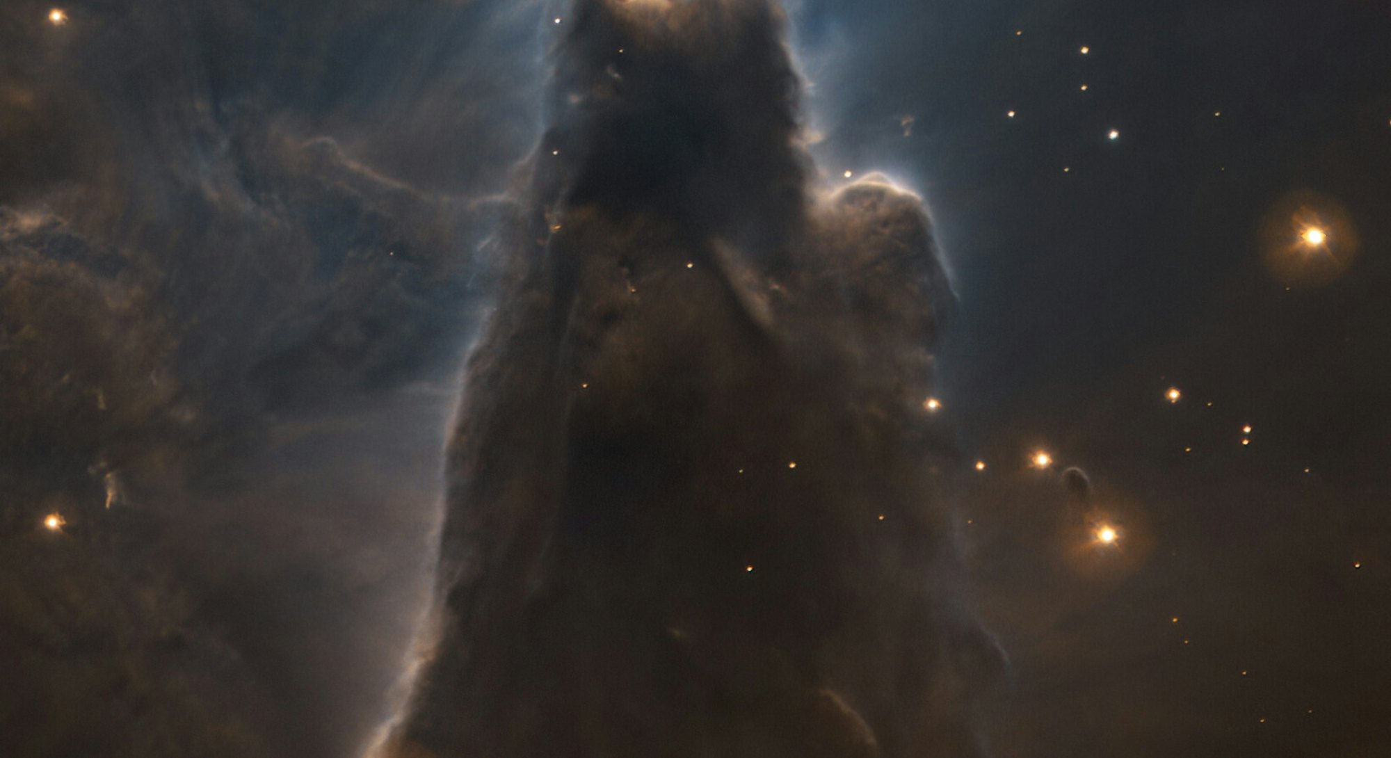 Dark pillar of dust rising in space with stars all around. Portrait of the cone nebula
