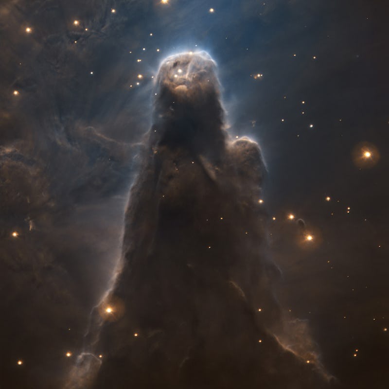 Dark pillar of dust rising in space with stars all around. Portrait of the cone nebula