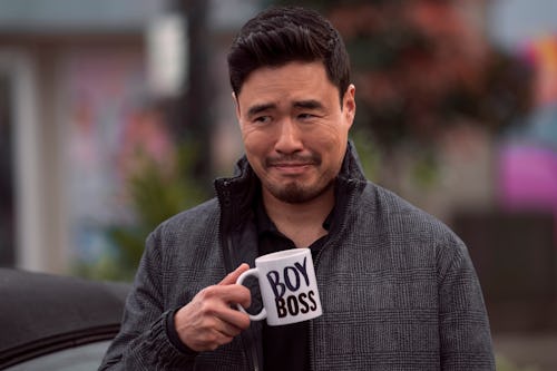 Randall Park as Timmy in episode 101 of 'Blockbuster' on Netflix.  He's holding a mug that says "BOY...