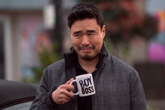 Randall Park as Timmy in episode 101 of 'Blockbuster' on Netflix.  He's holding a mug that says "BOY...