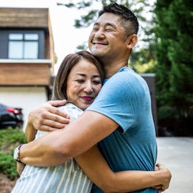 Happy asian couple smiling and hugging in a driveway