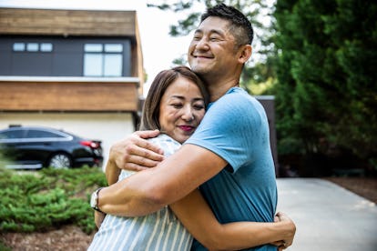 Happy asian couple smiling and hugging in a driveway