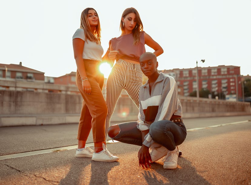 three friends pose for a photo during golden hour as they chat about their november 14, 2022 weekly ...