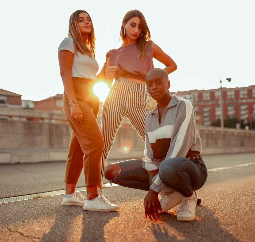 three friends pose for a photo during golden hour as they chat about their november 14, 2022 weekly ...