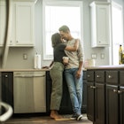 Husband and wife looking at one another tenderly in the kitchen