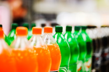 Soda bottles lined up on a store shelf
