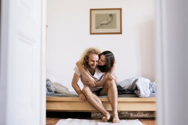 A man and woman sitting together in bed.