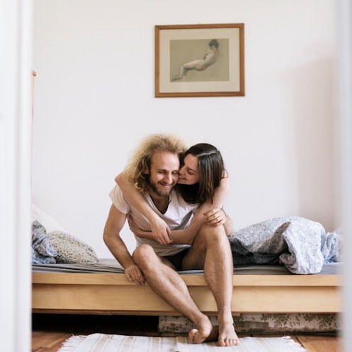 A man and woman sitting together in bed.