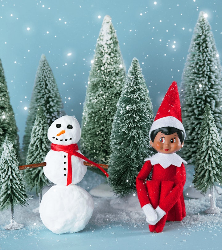 an elf on the shelf sitting in a winter scene in an article about elf on the shelf rules. 