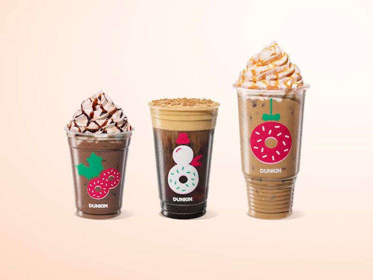 Three different Dunkin’s holiday drinks in Christmas themed cups.
