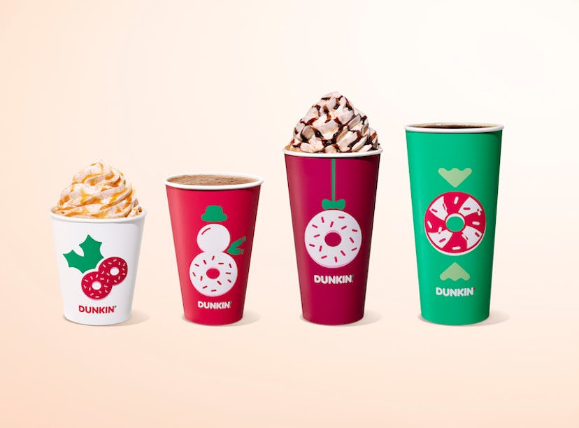 Four different Dunkin’s holiday drinks in Christmas themed cups.