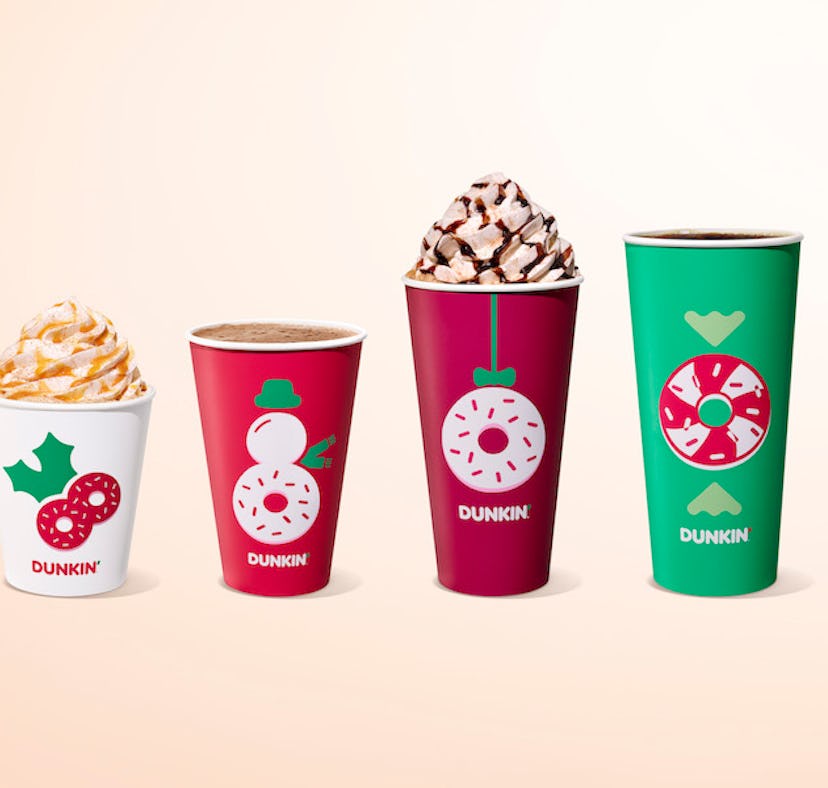 Four different Dunkin’s holiday drinks in Christmas themed cups.