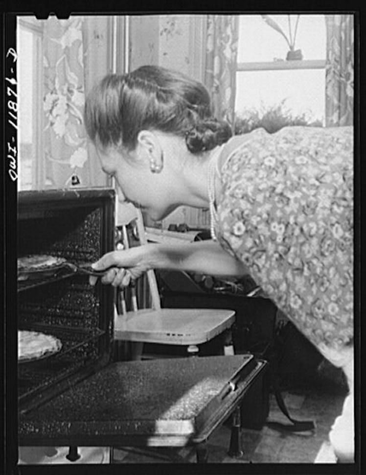 woman taking savory pies out oven