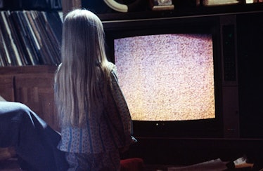 Carol Anne approaches the static TV when she hears voices.