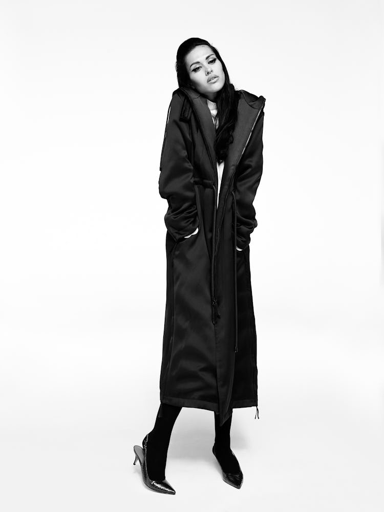 Model Amelia Gray wears black coat, black shoes and tights.