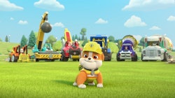 Rubble the bulldog stands in front of a fleet of construction vehicles in 'Rubble and Crew,' a 'PAW ...