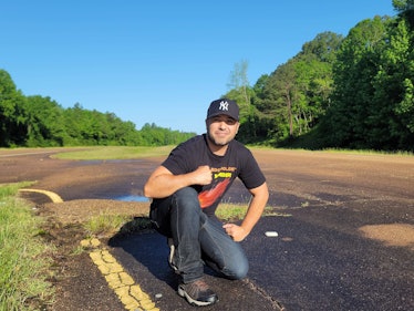 Matthew Stream kneels next to a meteorite in the road in Cranfield.
