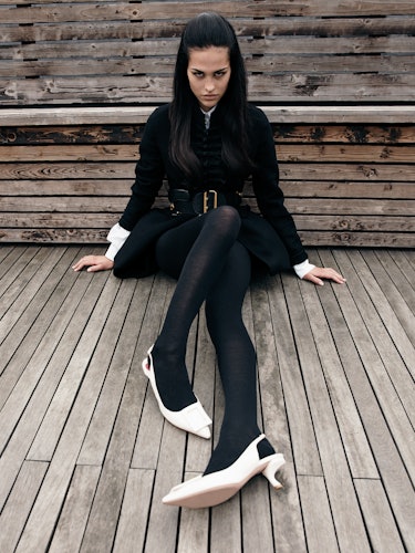 Model Amelia Gray wears white shoes, black coat and leather belt.