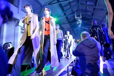 Models wearing clothes by Raf Simons on the runway. 