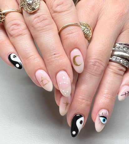 Sagittarius nail designs with constellations, moons and stars on a light pink base