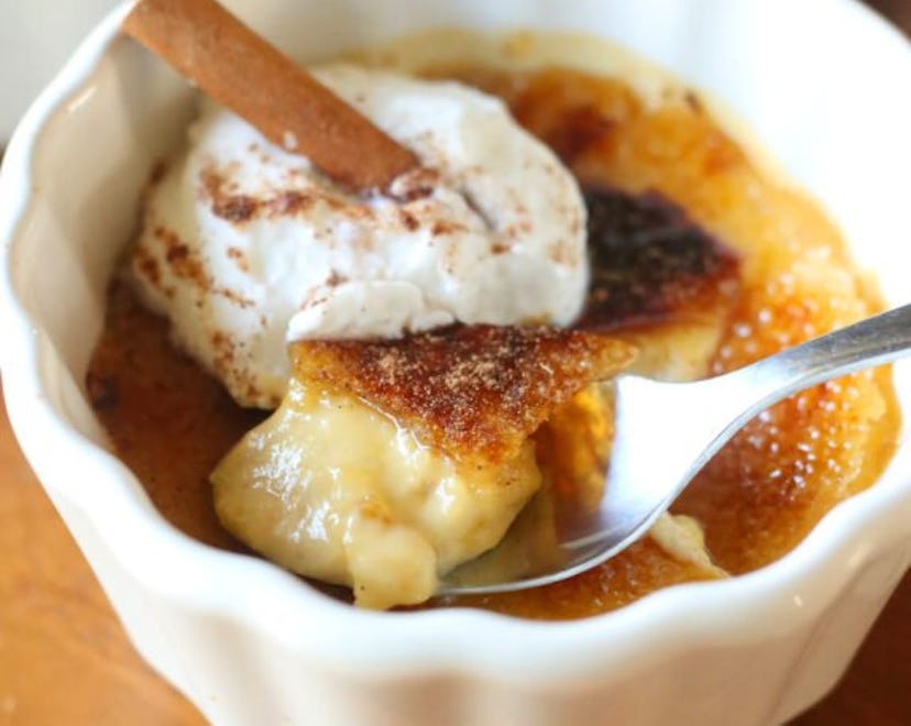 Pumpkin pie creme brulee in a ramekin topped with whipped cream and cinnamon
