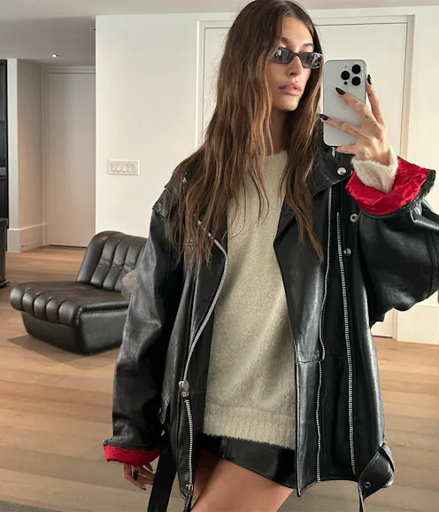 Hailey Bieber wearing an oversized black leather jacket.