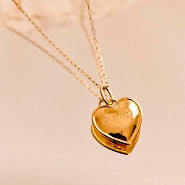a gold heart charm on a chain