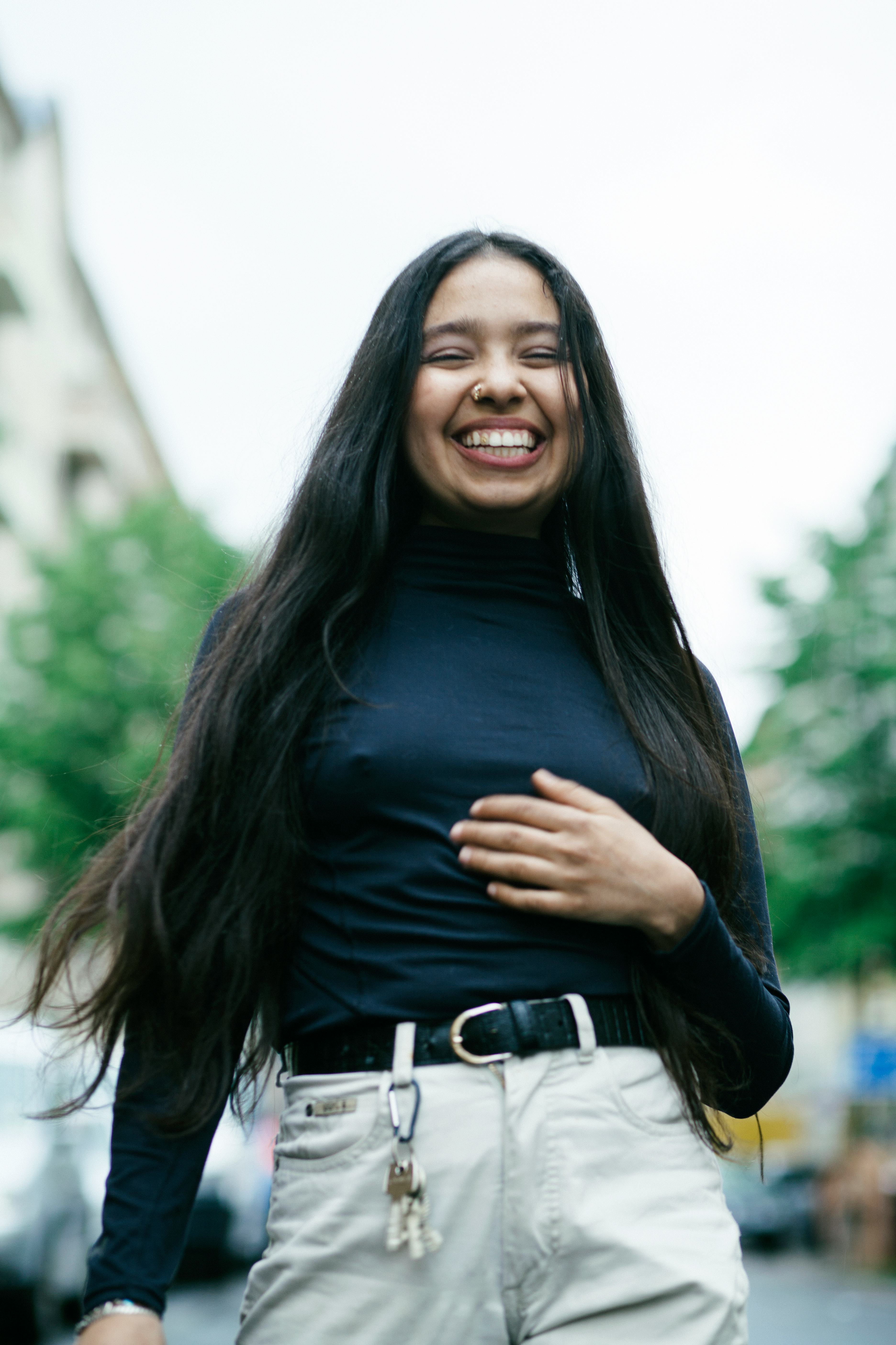 Young woman smiling and laughing as one of the luckiest zodiac signs in December 2022.