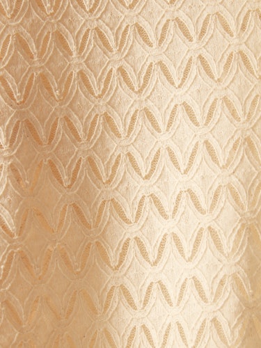 a close-up image of cream colored lace, showing the diamond shaped detail of the design