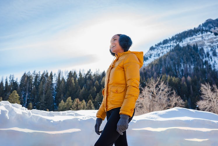 Young woman walking in the snow after reading her December 2022 horoscope.