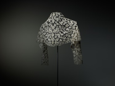 a lace bolero photographed from the back on a stand