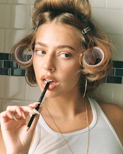 Model with arched brows and curlers