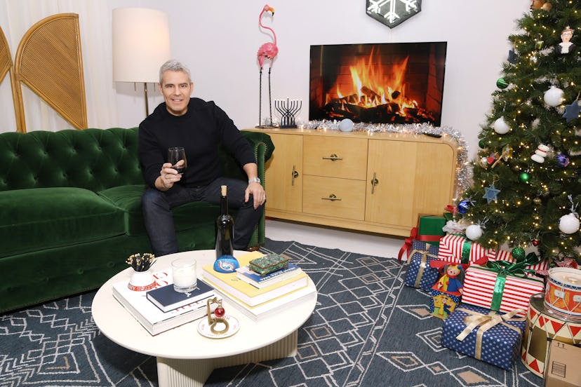 Andy Cohen sits in a festively decorated room.
