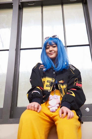 Young woman wearing a blue wig and yellow pants as Neptune retrograde 2022 ends.