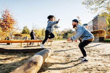 A father and a son playing on the playground, making the most of their custody weekend