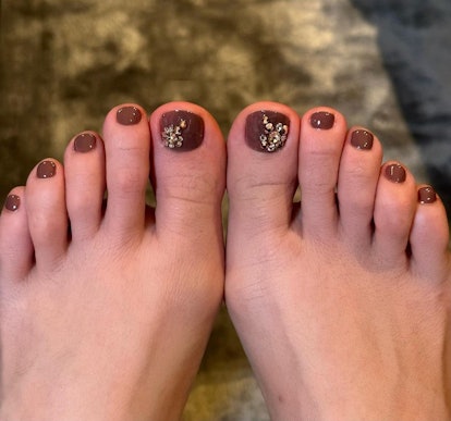Jennifer Lopez's feet in brown pedicure nail polish and gold crystals