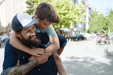 A bearded dad with a kid on his back.