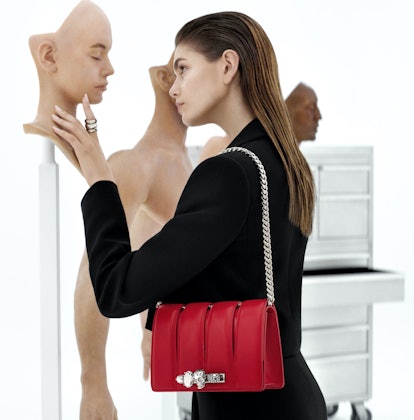 Kaia Gerber in Alexander McQueen campaign, staring at a lifelike clone face