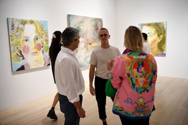 people in front of paintings of faces