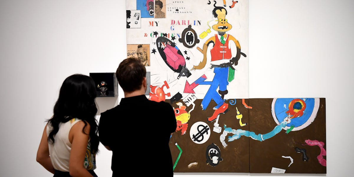 two people looking at a painting