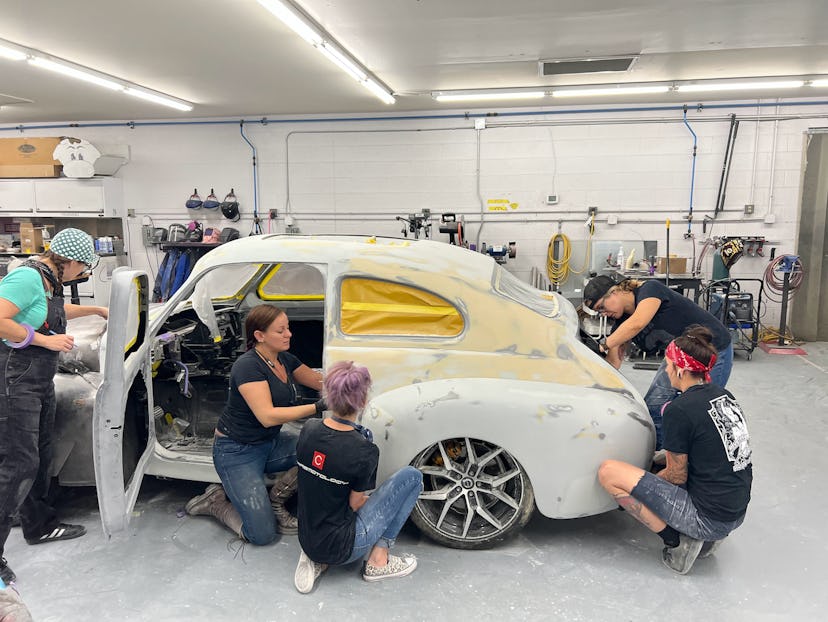 5 women work on a white vintage car for Girl Gang Garage's All-Female Build