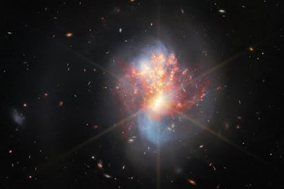 两个漩涡星系中心变成一个混乱的对象。长,蓝旋臂伸展已经……