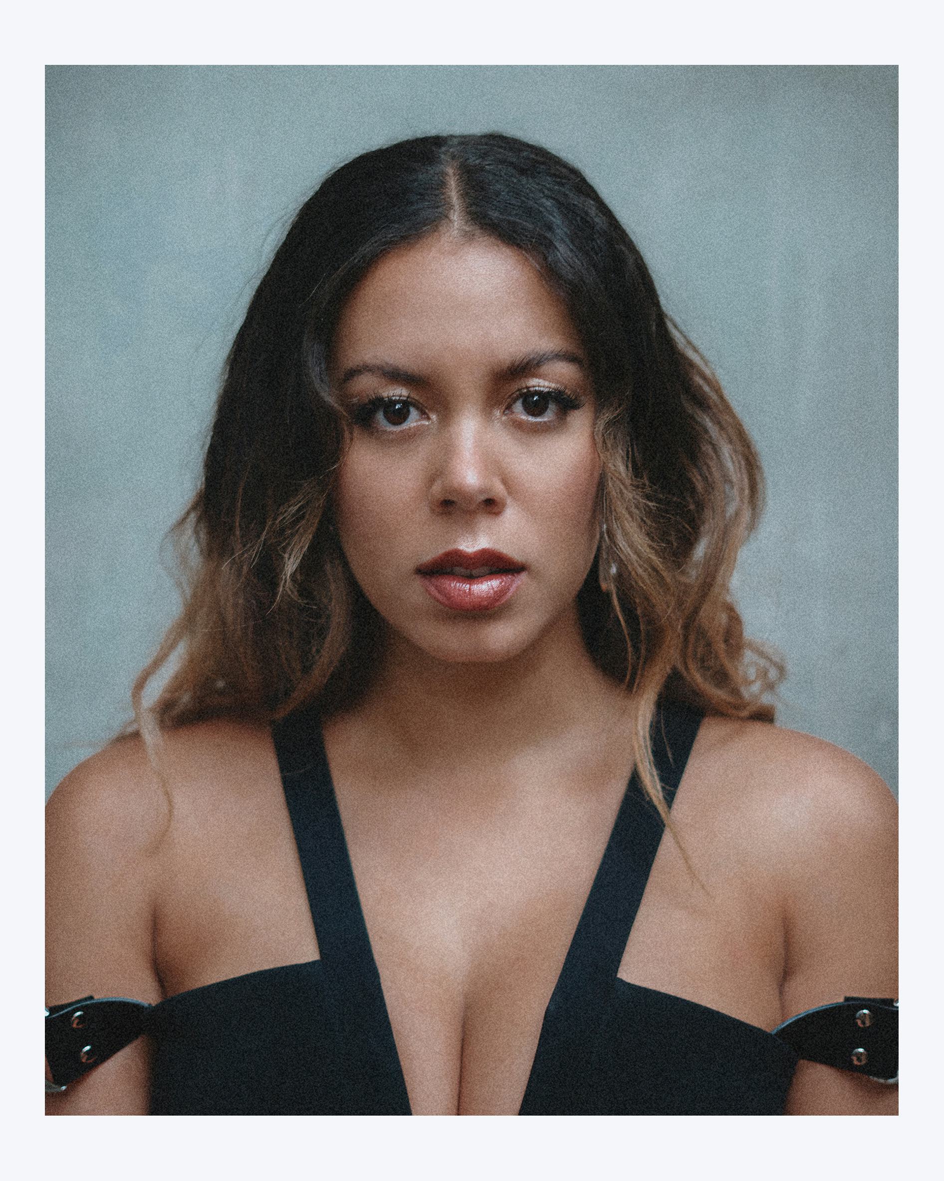 A portrait of Nicôle wearing a black dress