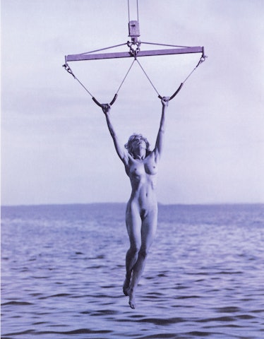 Madonna, nude, hanging from a boat lift. 