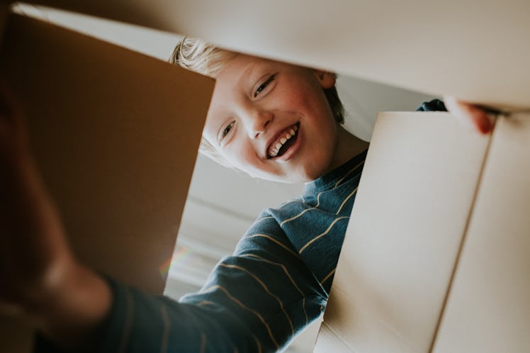 Young boy looking into box, smiling at what's inside