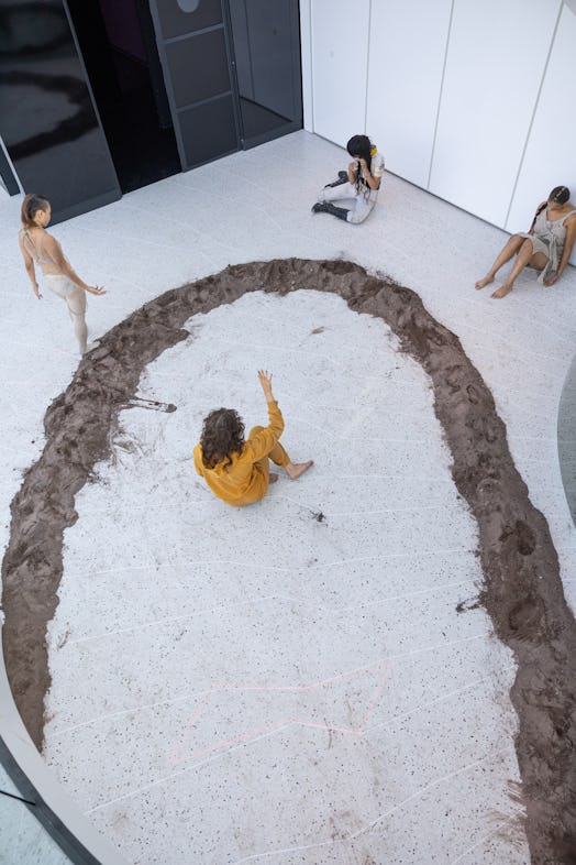a woman dancing in a dirt circle